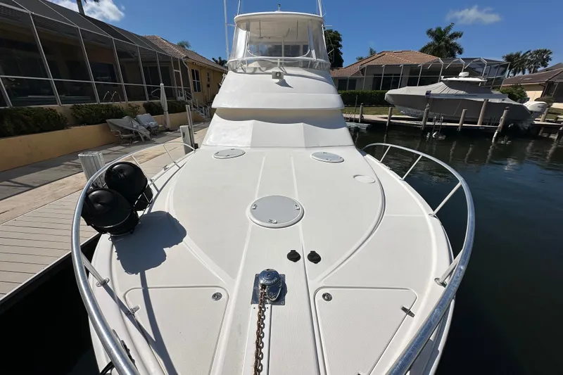 Slide: The Image of 2002 Riviera 40 Flybridge yacht docked, showcasing spacious deck and sleek design. - 20