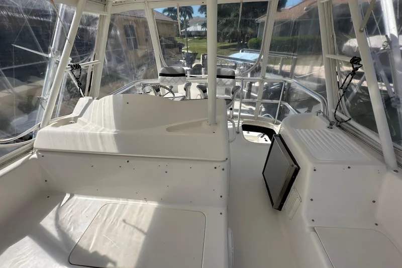 Slide: The Image of 2002 Riviera 40 Flybridge interior with helm and seating area, featuring clear windows. - 24