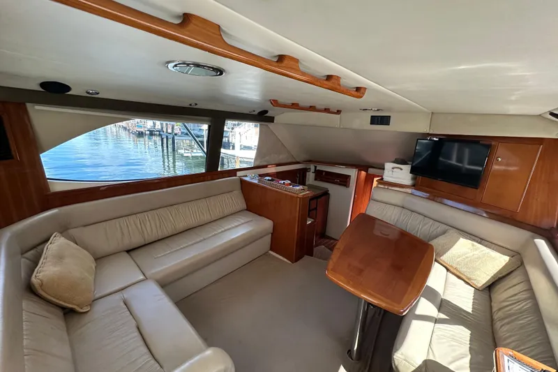 Slide: The Image of Luxurious interior of 2002 Riviera 40 Flybridge yacht with plush seating and wooden accents. - 28