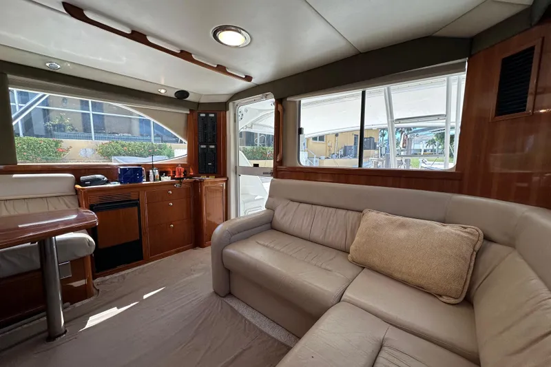 Slide: The Image of Luxurious interior of 2002 Riviera 40 Flybridge yacht with plush seating and wooden cabinetry. - 30
