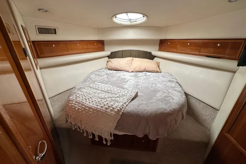 Slide: The Image of Cozy bedroom in 2002 Riviera 40 Flybridge yacht with plush bedding and wooden storage. - 40
