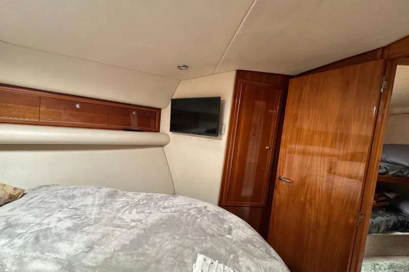 Slide: The Image of Interior of 2002 Riviera 40 Flybridge yacht bedroom with wood paneling and TV. - 42