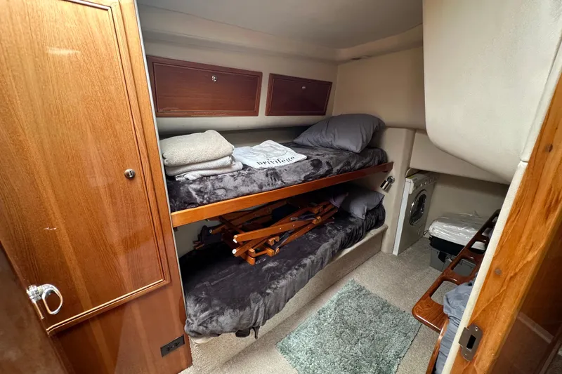 Slide: The Image of Interior of 2002 Riviera 40 Flybridge with cozy bunk beds and wooden cabinetry. - 43