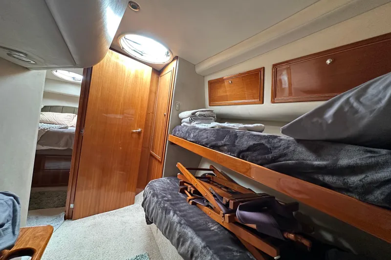 Slide: The Image of Interior of 2002 Riviera 40 Flybridge yacht with cozy bunk beds and wooden cabinetry. - 47