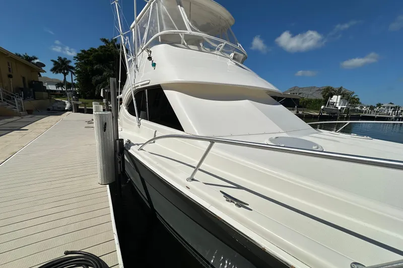 Slide: The Image of 2002 Riviera 40 Flybridge yacht docked under clear blue sky. - 8