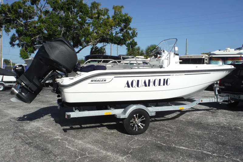 Slide: The Image of 2007 Boston Whaler 180 Dauntless boat on trailer, labeled "AQUAHOLIC," parked outdoors. - 0