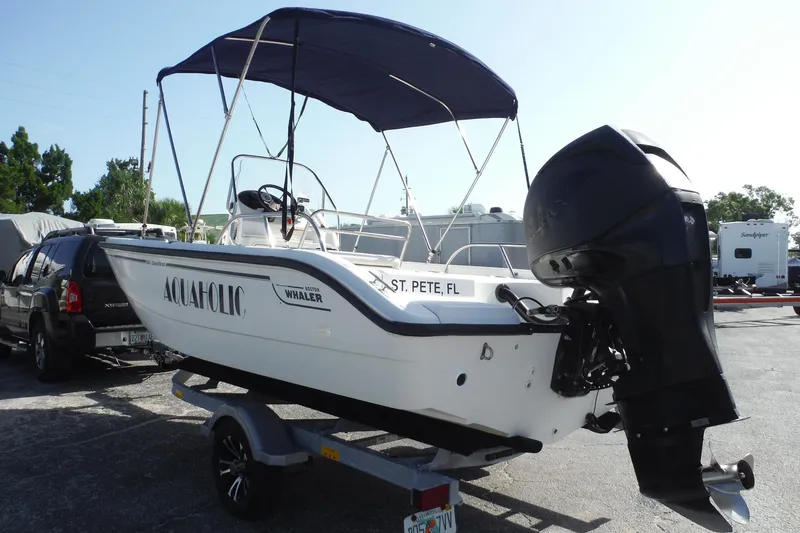 Slide: The Image of 2007 Boston Whaler 180 Dauntless boat with canopy, parked on trailer in sunny lot. - 26