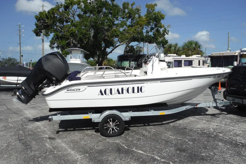 Slide: The Image of 2007 Boston Whaler 180 Dauntless boat on trailer, labeled "Aquaholic," parked outdoors. - 32