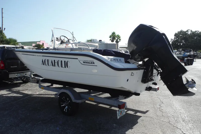 Slide: The Image of 2007 Boston Whaler 180 Dauntless boat on trailer, labeled "Aquaholic," parked outdoors. - 4