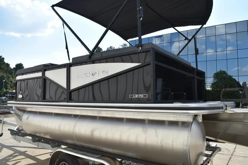 Slide: The Image of 2026 Lowe LS 170 pontoon boat with canopy, displayed outdoors. - 6