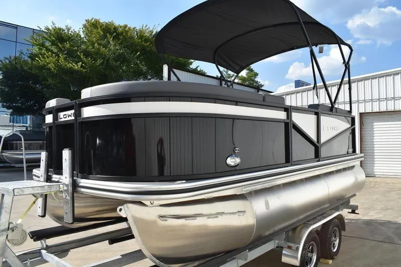 Slide: The Image of 2026 Lowe LS 170 pontoon boat on trailer, black exterior, parked outdoors. - 7