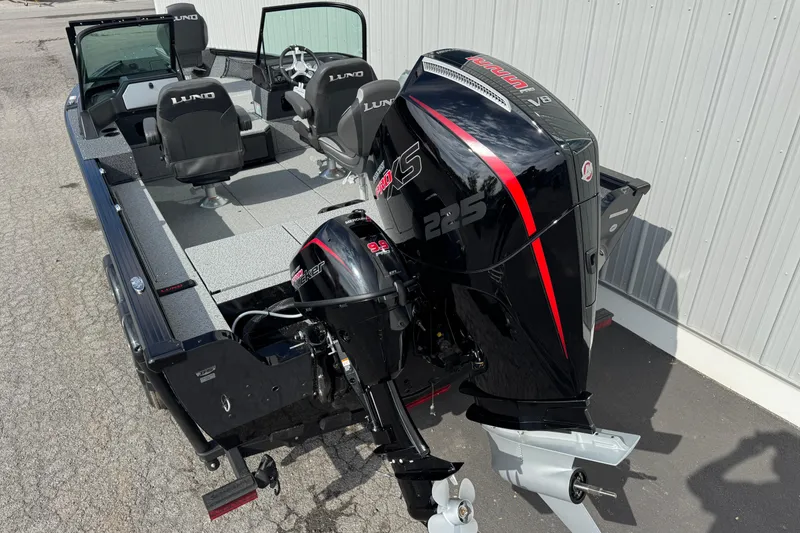 Slide: The Image of 2026 Lund 2075 Impact XS boat with powerful outboard motor, parked on pavement. - 3
