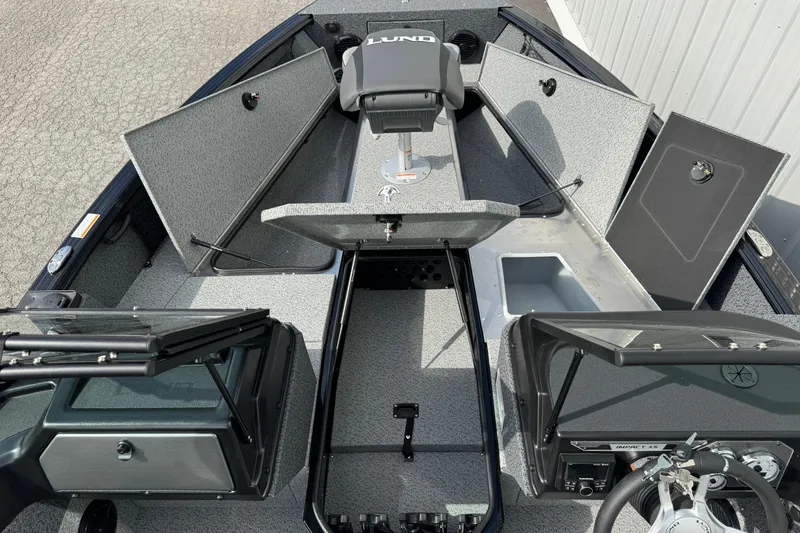 Slide: The Image of 2026 Lund 2075 Impact XS boat interior with open storage compartments and steering console. - 6