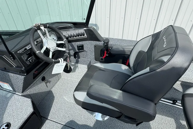 Slide: The Image of 2026 Lund 2075 Impact XS boat interior with steering wheel and captain's seat. - 8