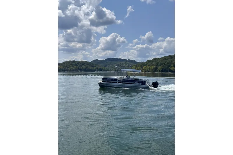 Slide: The Image of 2024 Godfrey SWEETWATER 2486 DT pontoon boat cruising on a scenic lake. - 8