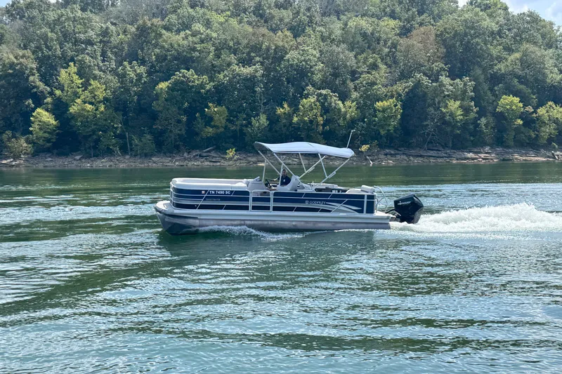 Slide: The Image of 2024 Godfrey SWEETWATER 2486 DT pontoon boat cruising on a scenic lake. - 9