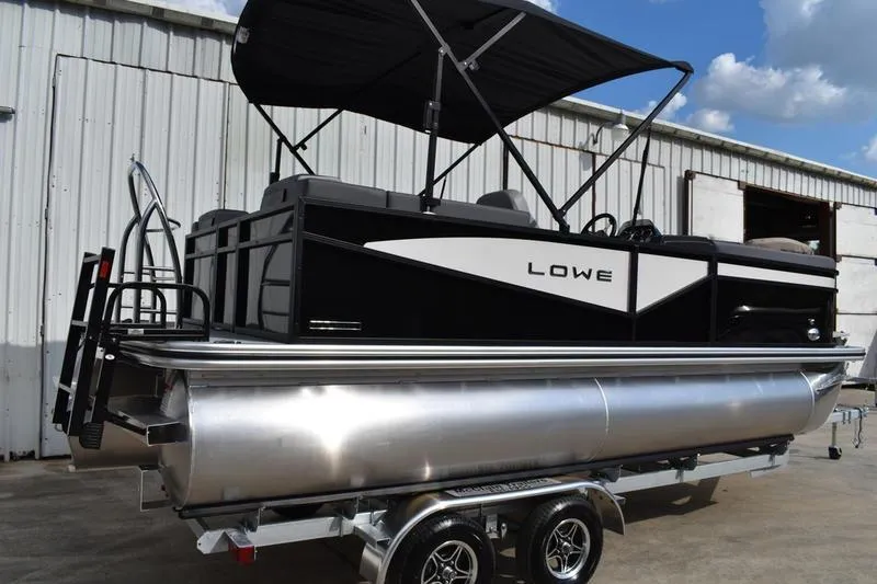 Slide: The Image of 2026 Lowe LS 210 WT pontoon boat on trailer, sleek design, reflective building background. - 5