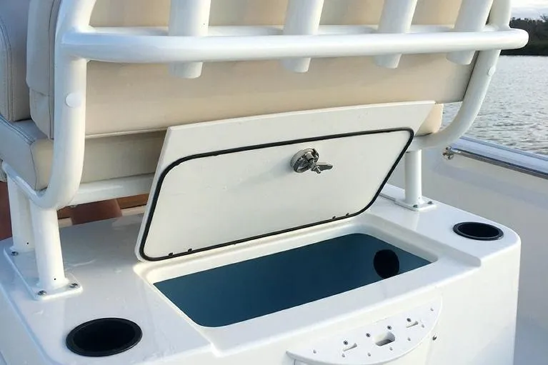Slide: The Image of Manufacturer Provided Image: 2026 Boston Whaler 210 Montauk boat storage compartment with open lid and cup holders. - 13
