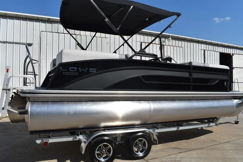Slide: The Image of 2026 Lowe SS 230 pontoon boat on McClain trailer, close-up view. - 2
