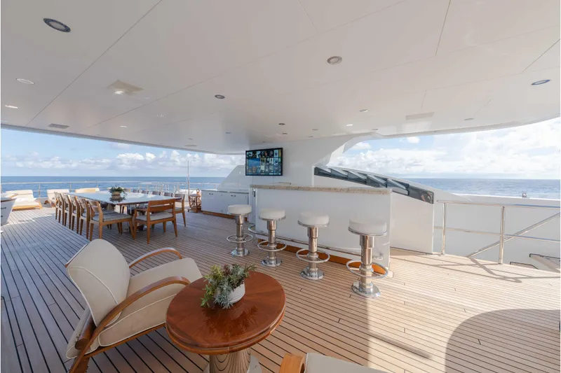 Slide: The Image of Luxurious 2013 Feadship motor yacht deck with bar, dining area, and ocean view. - 57
