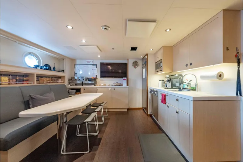 Slide: The Image of Modern kitchen interior on 2013 Feadship motor yacht, featuring sleek cabinetry and dining area. - 79
