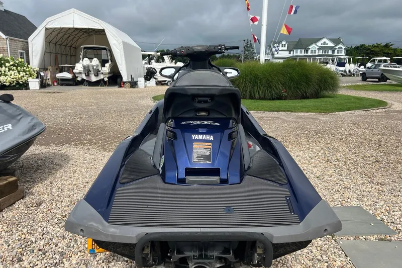 Slide: The Image of 2014 Yamaha WaveRunner FX Cruiser SVHO parked on gravel near boats and flags. - 5