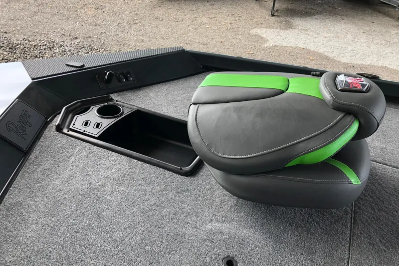 Slide: The Image of 2026 Ranger RT178 boat seat with green accents on gray carpeted deck. - 12