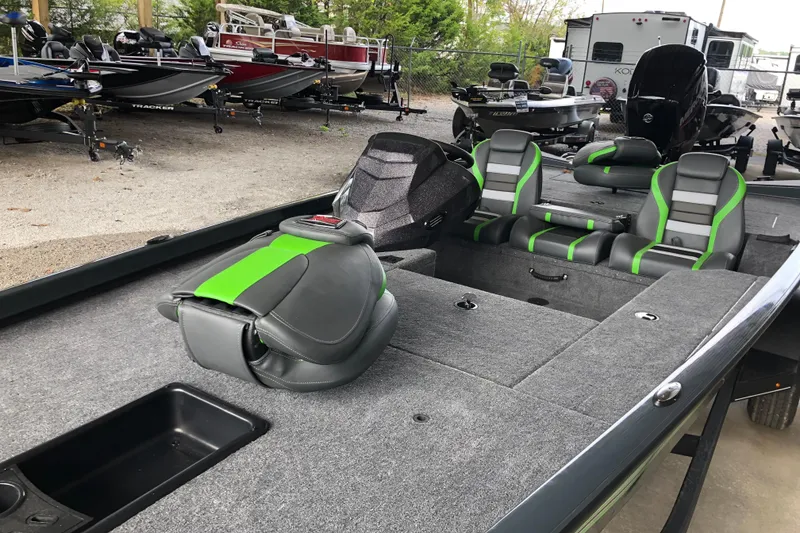Slide: The Image of 2026 Ranger RT178 boat interior with gray and green seats, parked among other boats. - 7