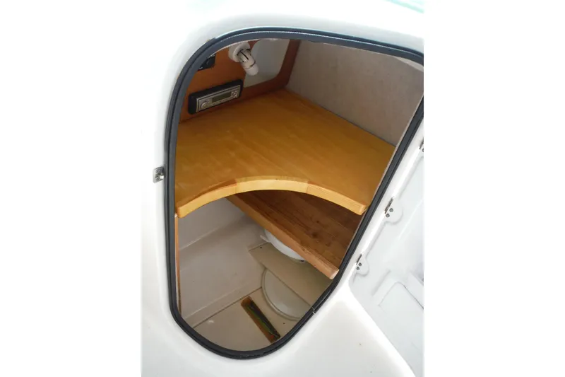 Slide: The Image of 2007 Robalo R227 Dual Console cabin interior with wooden shelf and storage space. - 11