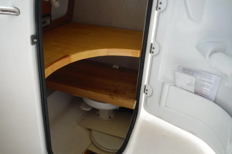 Slide: The Image of 2007 Robalo R227 Dual Console boat interior with wooden storage area. - 12