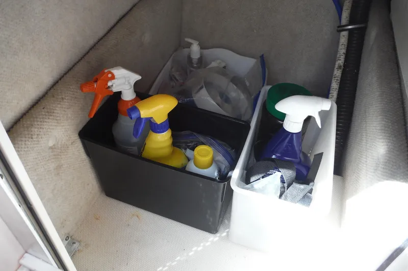 Slide: The Image of Cleaning supplies stored in a 2007 Robalo R227 Dual Console boat compartment. - 13