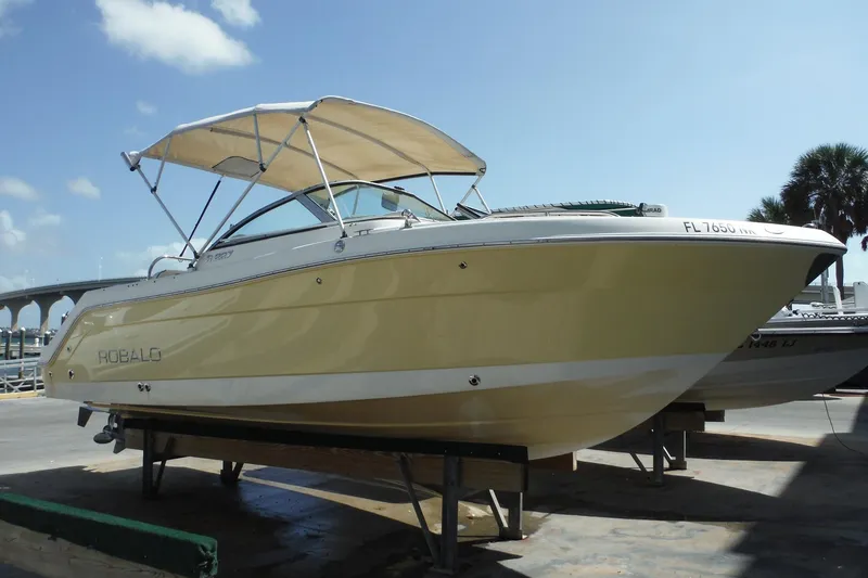 Slide: The Image of 2007 Robalo R227 Dual Console boat with canopy, docked under clear blue sky. - 2