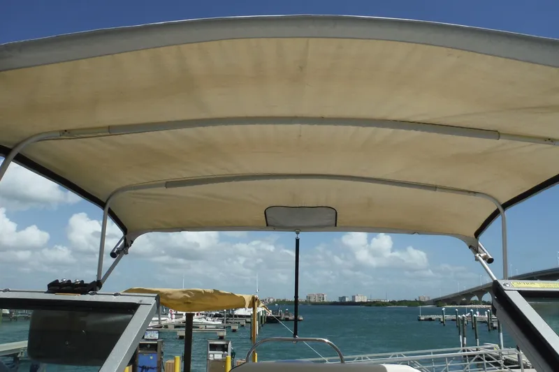 Slide: The Image of 2007 Robalo R227 Dual Console boat with canopy, docked by the waterfront under a clear sky. - 27