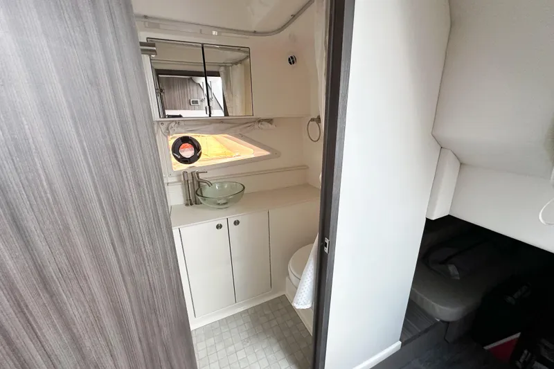 Slide: The Image of 2026 Sea Ray Sundancer 320 bathroom with modern fixtures and open cabinet. - 31
