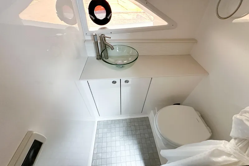 Slide: The Image of Interior cabin of 2026 Sea Ray Sundancer 320 with storage boxes and cushions. - 32