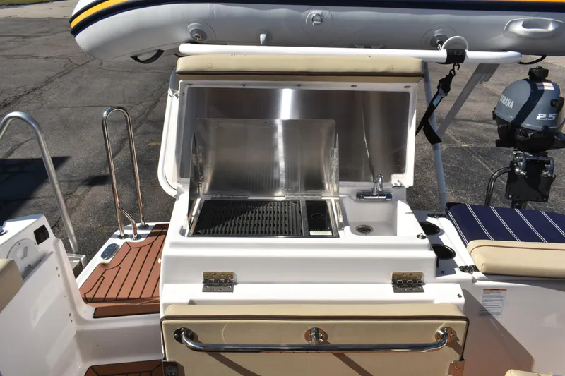 Slide: The Image of 2024 Ranger Tugs R-27 boat with outdoor kitchen and grill setup. - 21