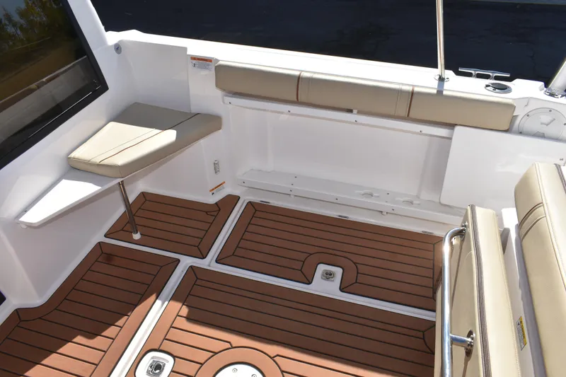 Slide: The Image of 2024 Ranger Tugs R-27 boat interior with cushioned seating and wood-patterned flooring. - 22