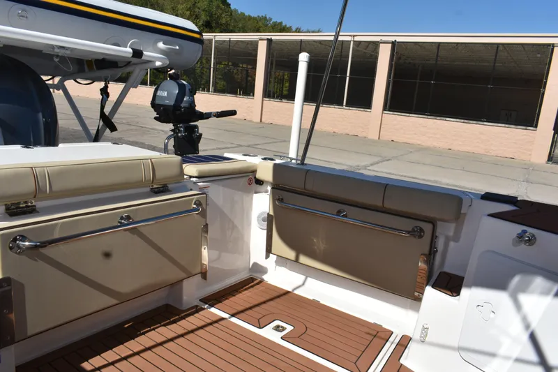 Slide: The Image of 2024 Ranger Tugs R-27 boat interior with cushioned seating and Yamaha motor. - 23
