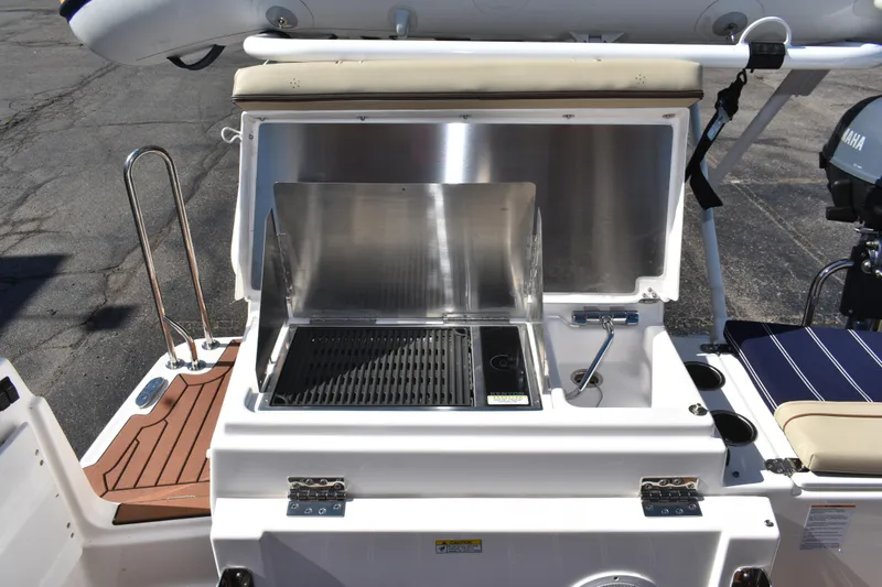 Slide: The Image of Outdoor grill on 2024 Ranger Tugs R-27 boat, featuring stainless steel design and seating area. - 25