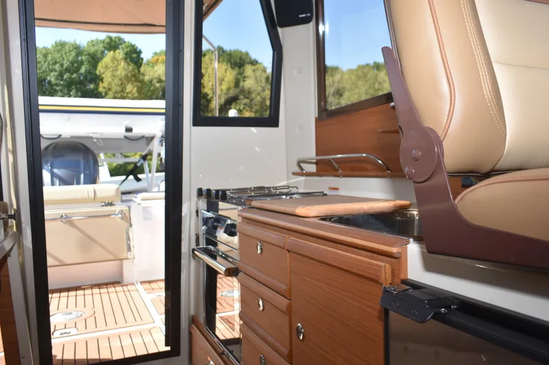 Slide: The Image of Interior of 2024 Ranger Tugs R-27, featuring a modern kitchen and seating area. - 27