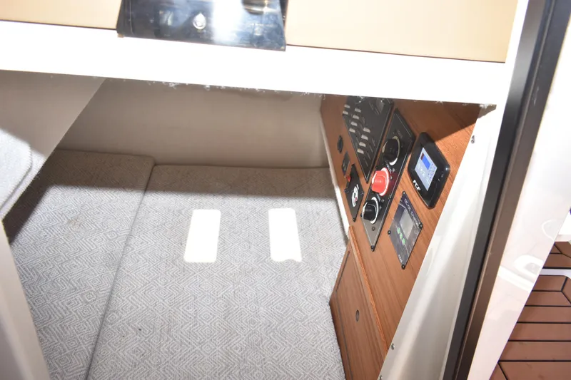Slide: The Image of 2024 Ranger Tugs R-27 interior with control panel and carpeted flooring. - 30