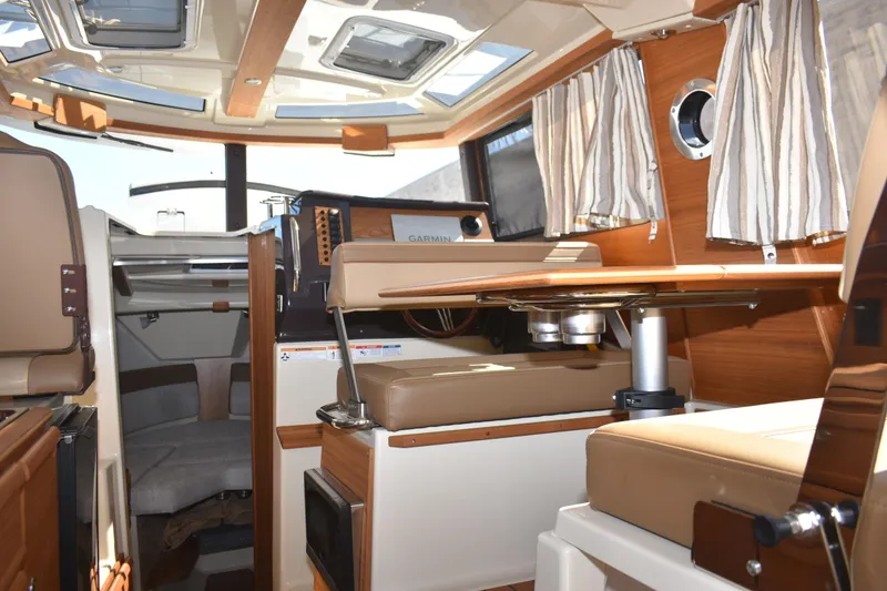 Slide: The Image of 2024 Ranger Tugs R-27 interior with seating, table, and navigation equipment. - 34