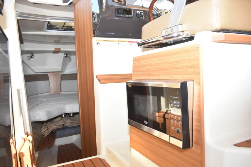 Slide: The Image of 2024 Ranger Tugs R-27 interior with microwave and cozy cabin area. - 38