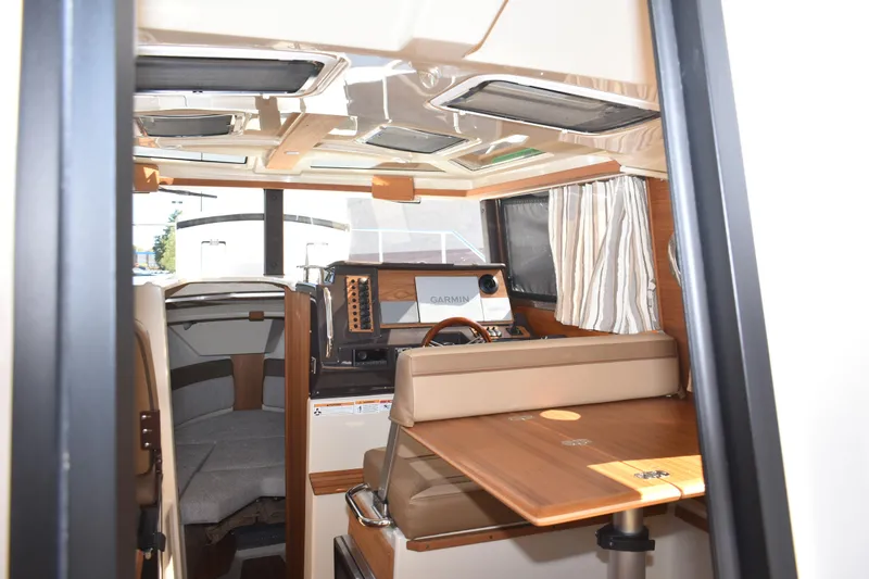 Slide: The Image of Interior of 2024 Ranger Tugs R-27 boat, featuring helm and seating area. - 47