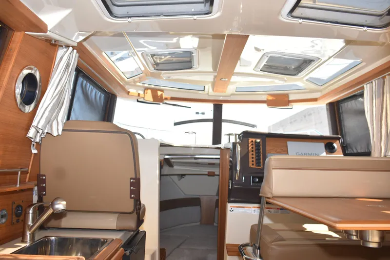 Slide: The Image of 2024 Ranger Tugs R-27 interior with modern design, skylights, and navigation equipment. - 50