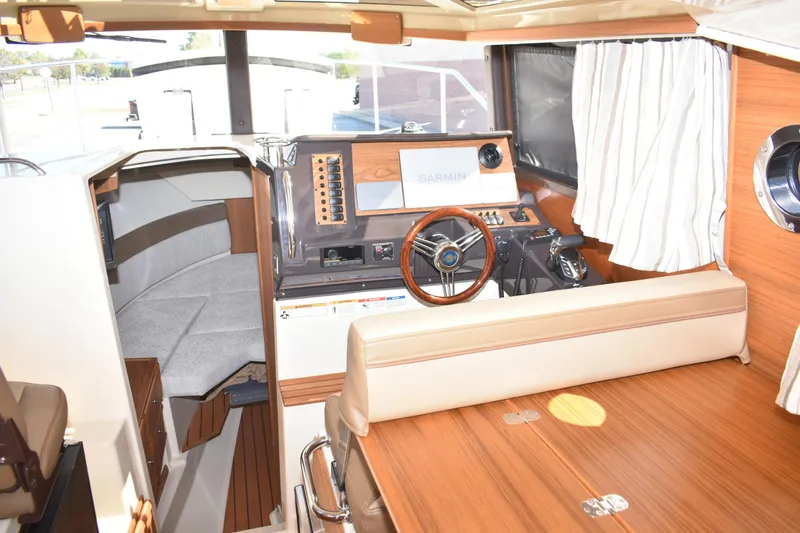 Slide: The Image of 2024 Ranger Tugs R-27 interior with helm, seating, and navigation equipment. - 54