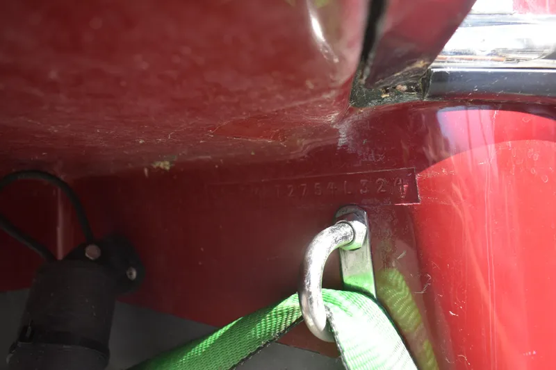 Slide: The Image of 2024 Ranger Tugs R-27 hull identification number with green strap and metal hook. - 60