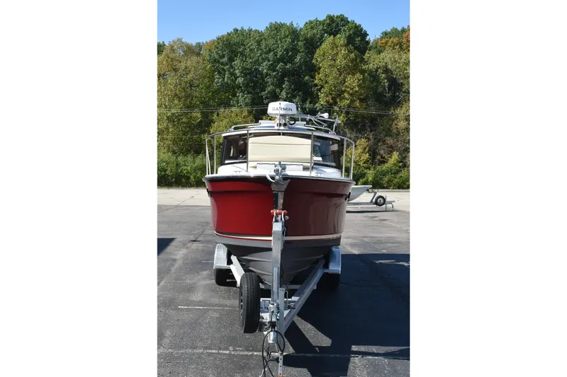 Slide: The Image of 2024 Ranger Tugs R-27 boat on trailer, front view, surrounded by trees. - 8