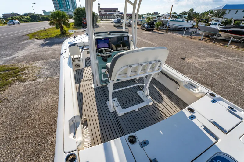 Slide: The Image of 2020 Tidewater 2500 Carolina Bay boat interior with helm and seating, parked near marina. - 16
