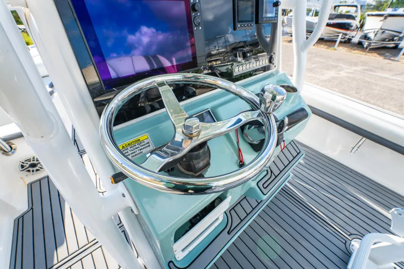 Slide: The Image of 2020 Tidewater 2500 Carolina Bay boat helm with steering wheel and control panel. - 23